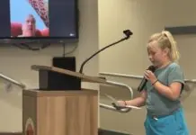 a little girl standing at a podium with a microphone