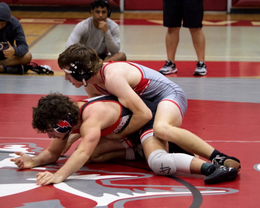 a wrestling match with two wrestlers on the ground