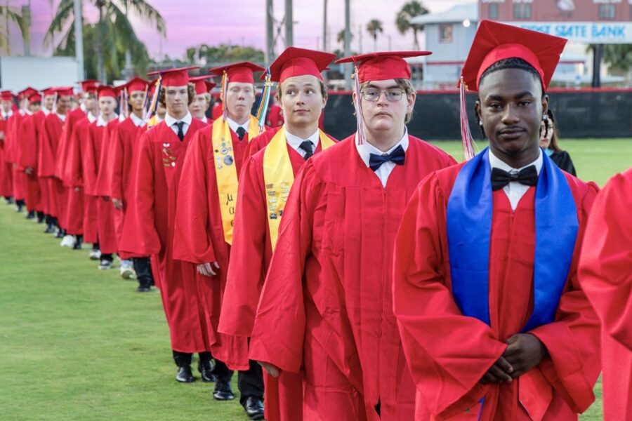 a group of people in graduation gowns standing on a field