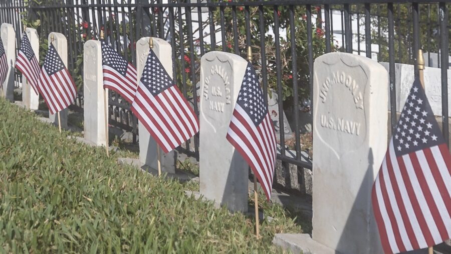 a row of headstones with american flags on them