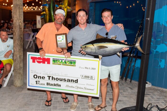 a group of men standing next to each other holding a check