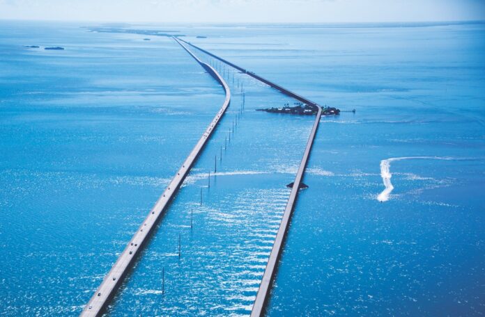 an aerial view of a long bridge in the middle of the ocean