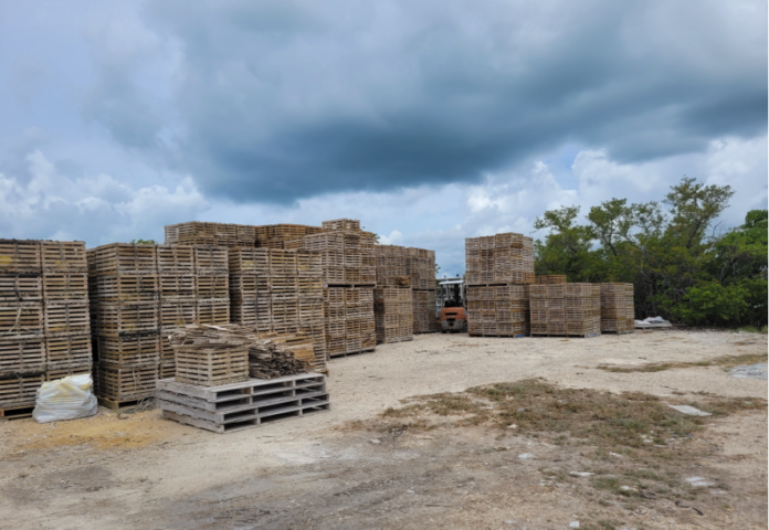 Sojourn property a pile of wooden pallets sitting on top of a dirt field