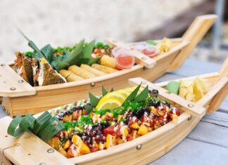two wooden boats filled with food sitting on top of a table