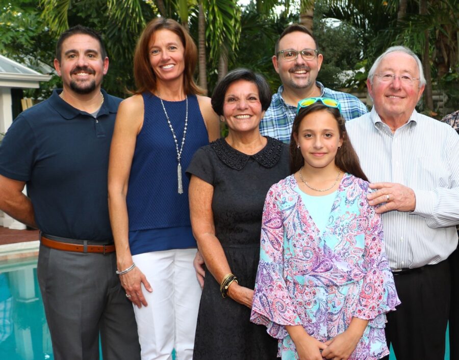 a group of people standing next to a swimming pool