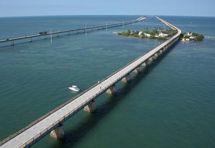an aerial view of a bridge spanning the ocean