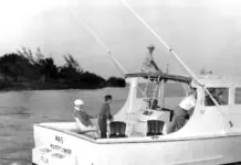 a black and white photo of two men on a boat
