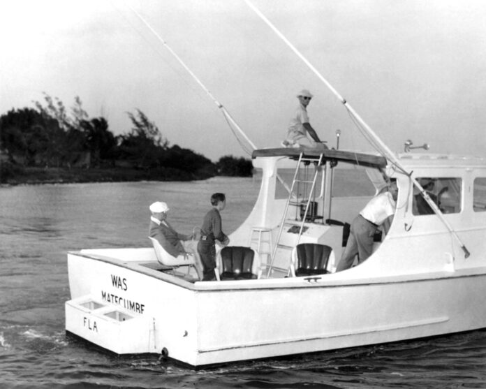 a black and white photo of two men on a boat