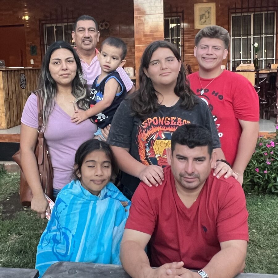 a group of people posing for a picture in front of a house