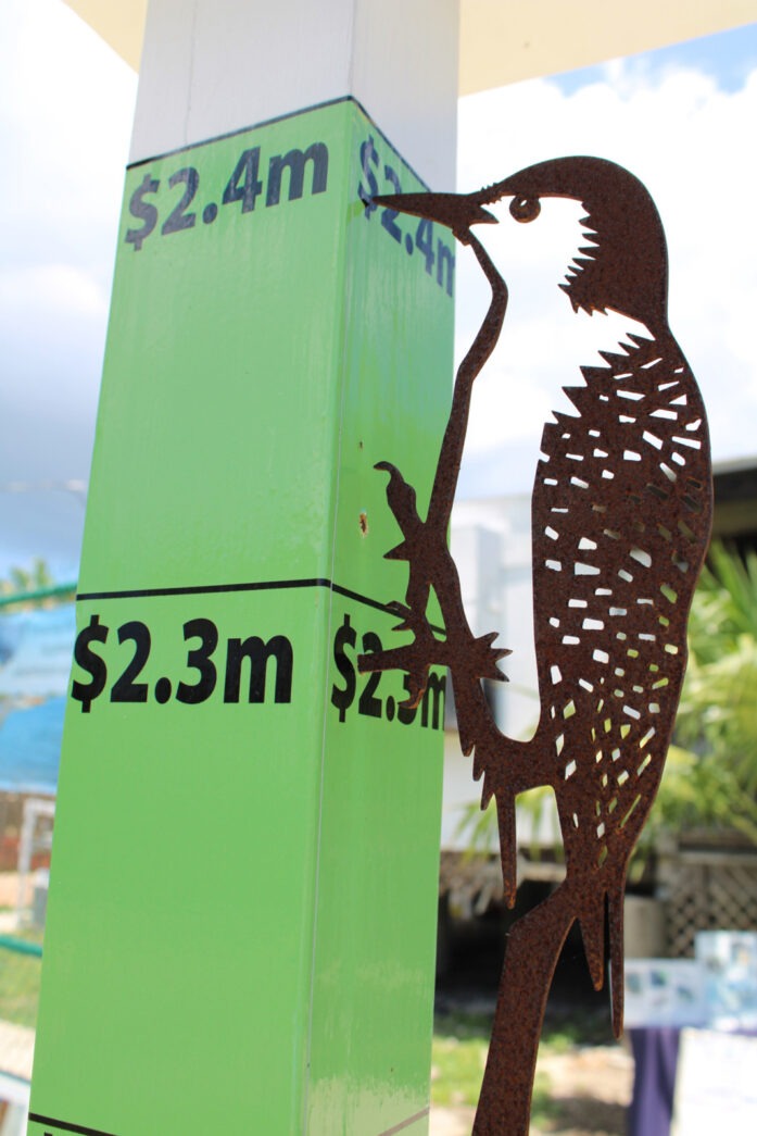 a metal bird on a pole with a price tag