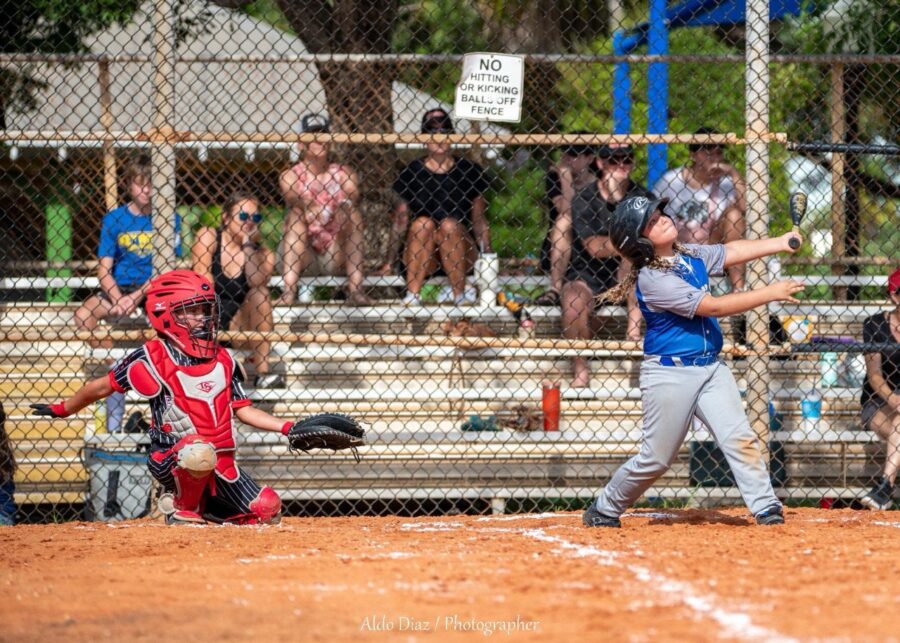 a young boy swinging a baseball bat at a ball