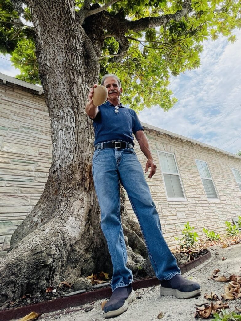 a man leaning against a tree in front of a house