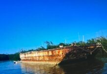 an old rusted boat sitting in the water