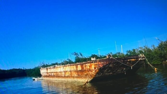 an old rusted boat sitting in the water