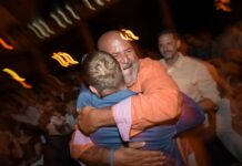 a couple of men hugging each other at a party