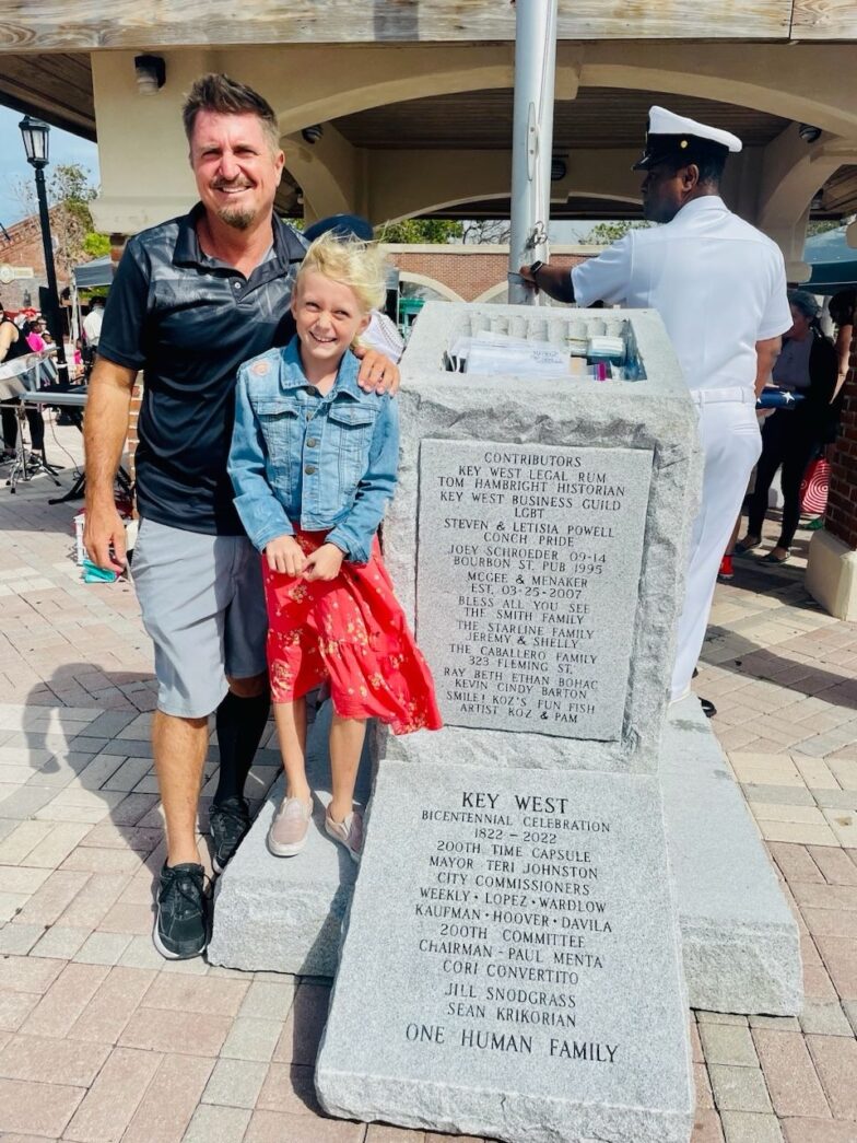 a man and a little girl standing next to a monument