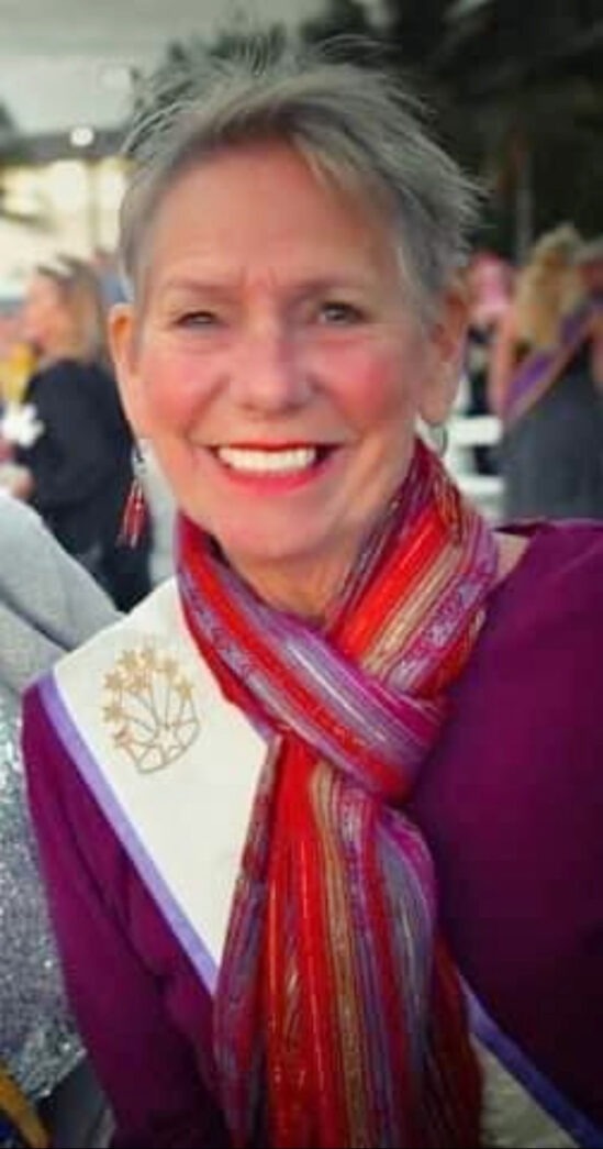 a woman wearing a scarf and smiling at the camera