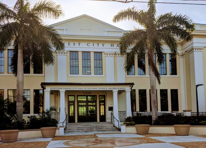 a large white building with palm trees in front of it