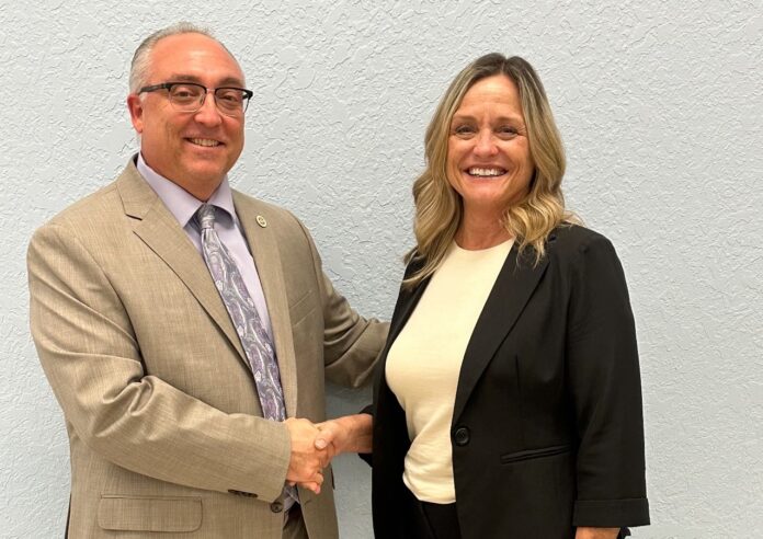 a man and a woman shaking hands in front of a wall