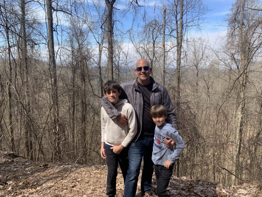 a man and two children standing on a hill