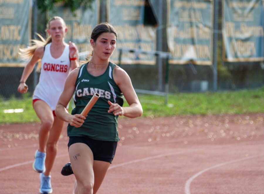 a couple of women running across a track