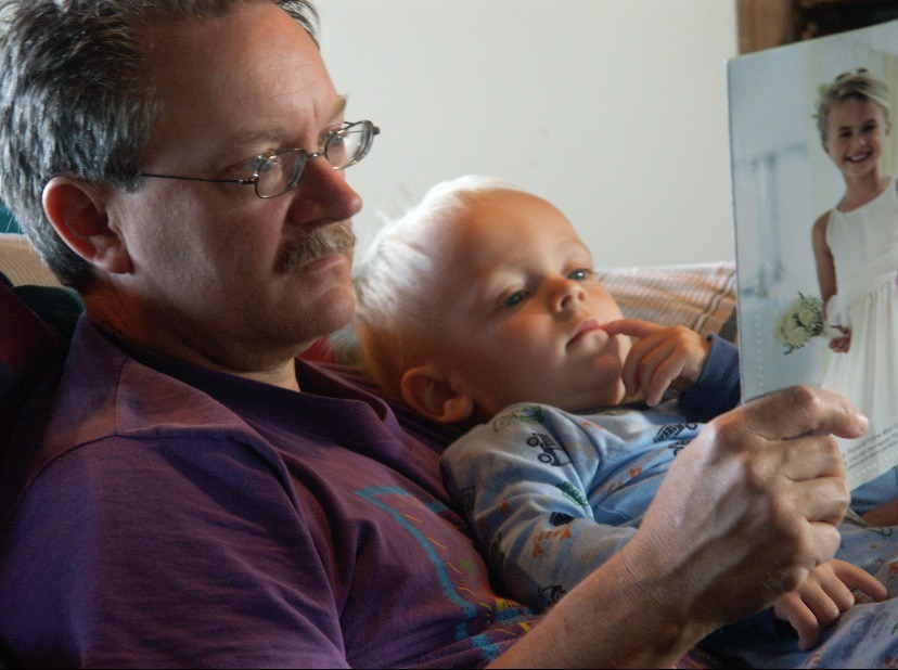 a man sitting on a couch holding a baby