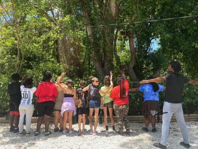 a group of people standing in front of a tree