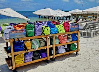 a wooden cart filled with bags on top of a beach