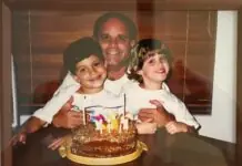 a picture of a man and two children with a birthday cake