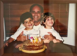 a picture of a man and two children with a birthday cake