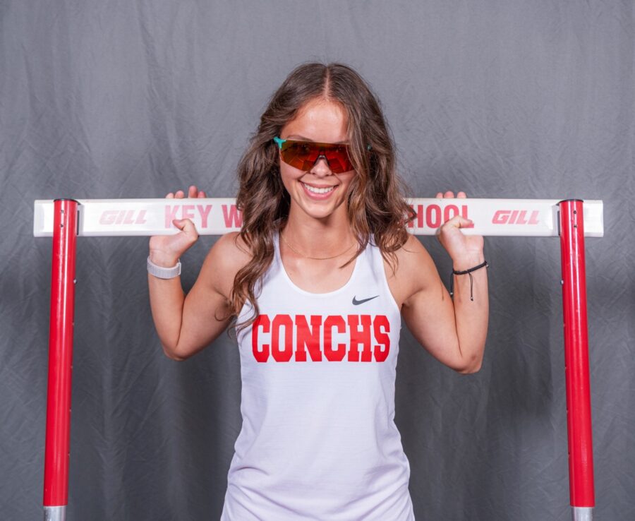 a woman in a tank top holding a barbell