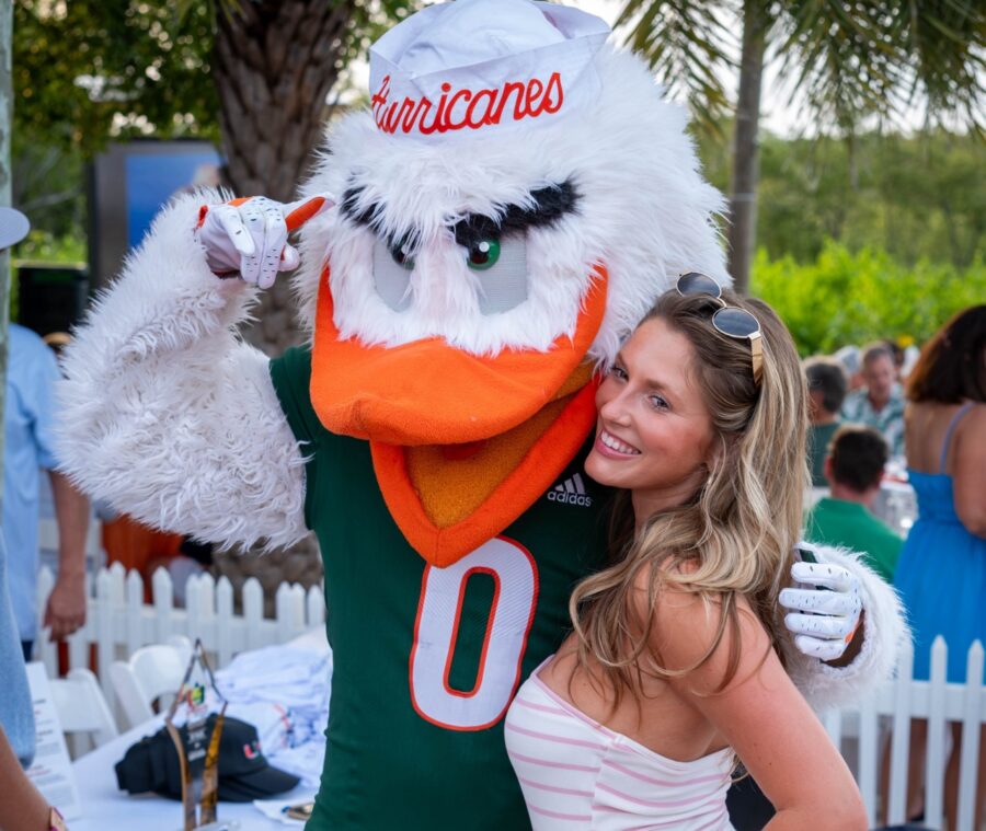 a woman standing next to a mascot at a party