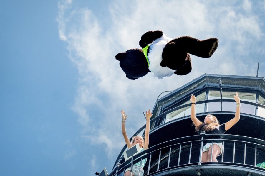 a group of people flying through the air on top of a building