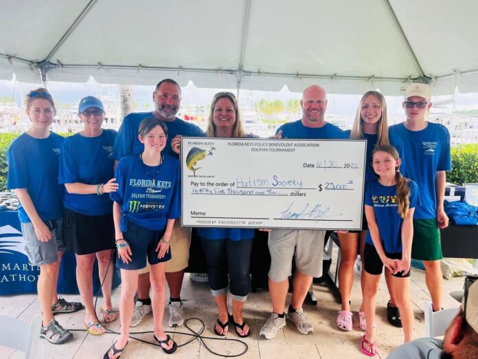 a group of people standing around a giant check