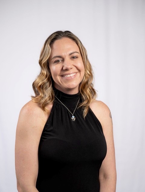 a woman in a black top is posing for a picture