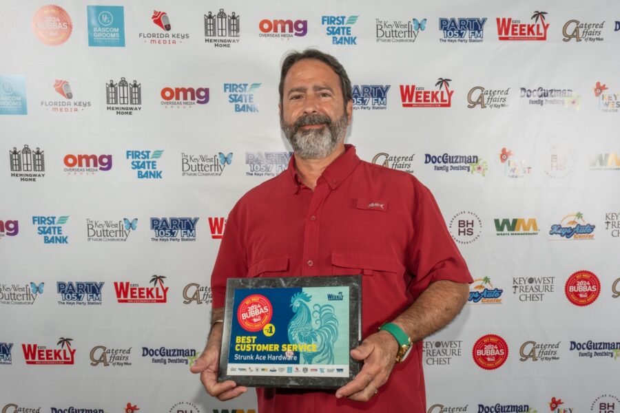 a man in a red shirt holding a plaque