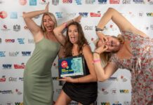 a group of women standing next to each other on a red carpet