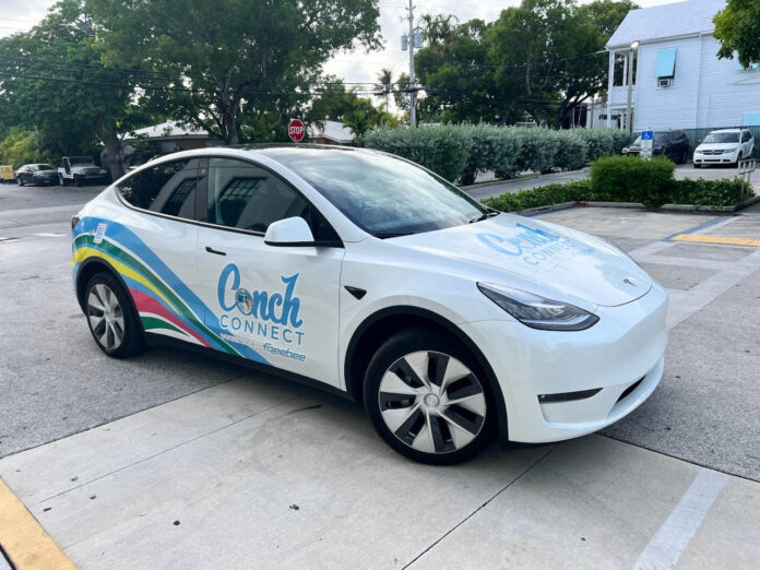 a white electric car parked in a parking lot