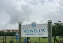 a sign for rowell's waterfront park on a cloudy day