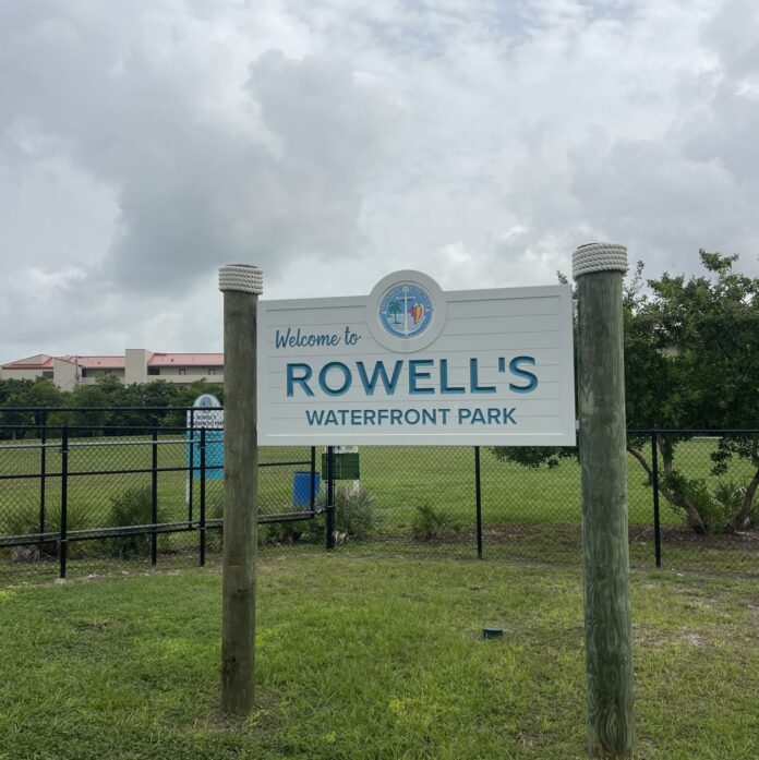 a sign for rowell's waterfront park on a cloudy day