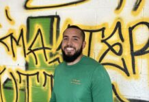 a man standing in front of a wall covered in graffiti