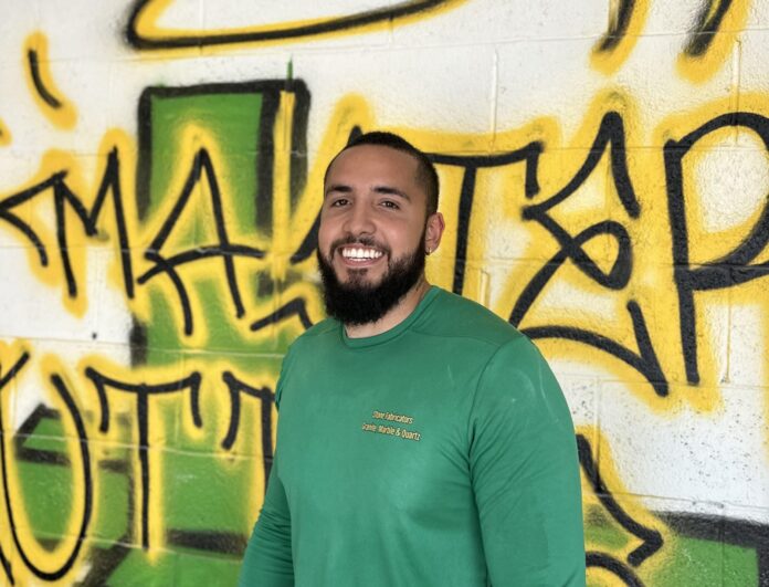 a man standing in front of a wall covered in graffiti