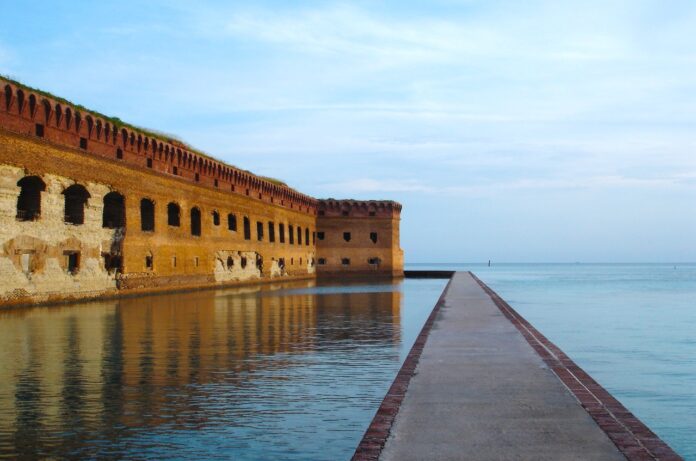 Fort Jefferson Large a long brick wall next to a body of water