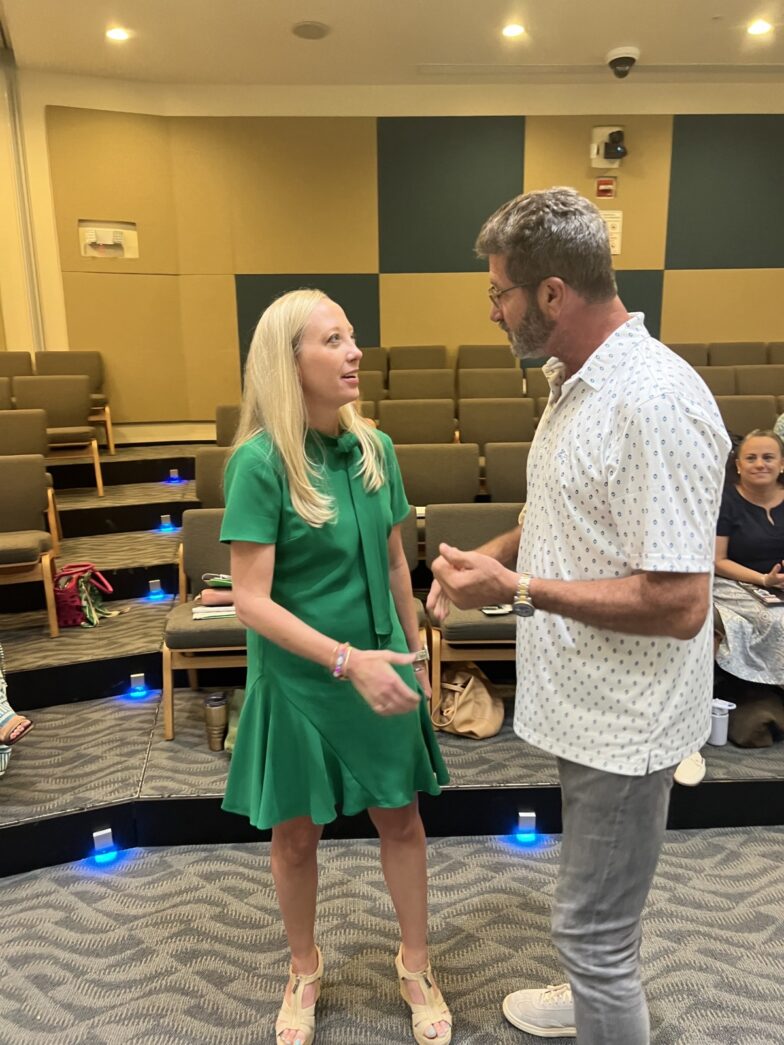 a man standing next to a woman in a green dress