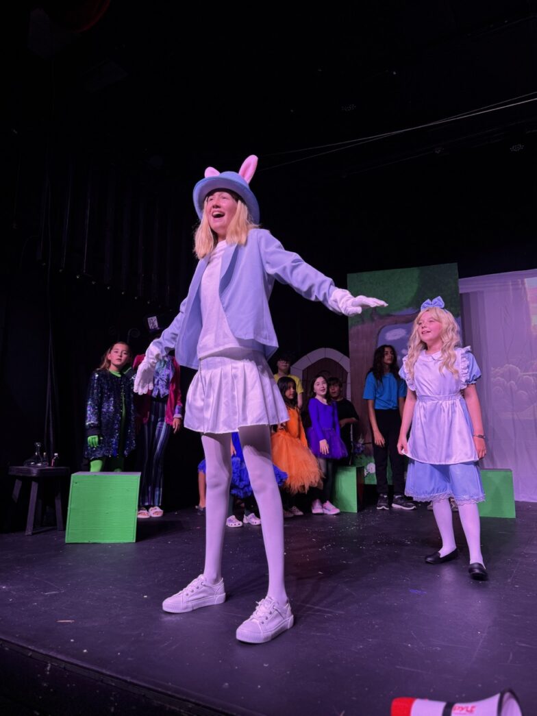 a group of children on a stage performing a musical