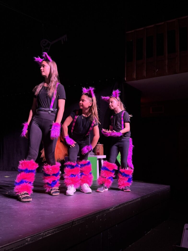 a group of women standing on top of a stage