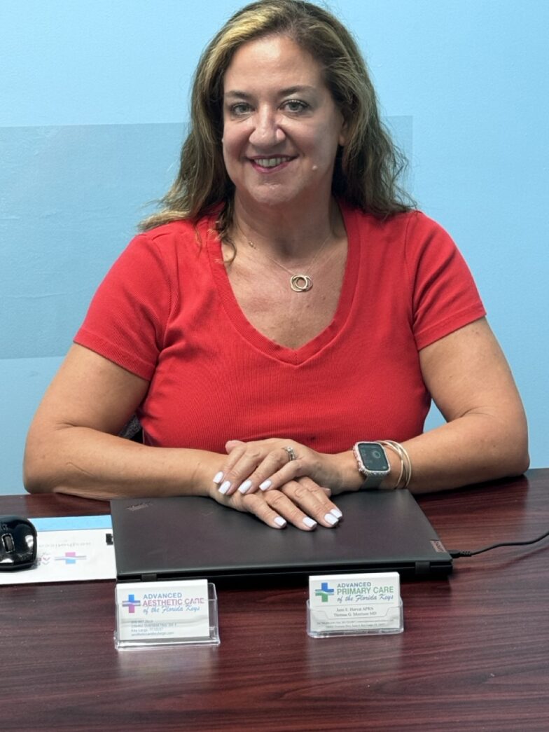 a woman sitting at a table with a laptop