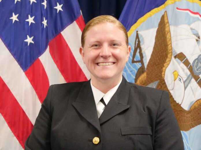 a woman in uniform standing in front of flags