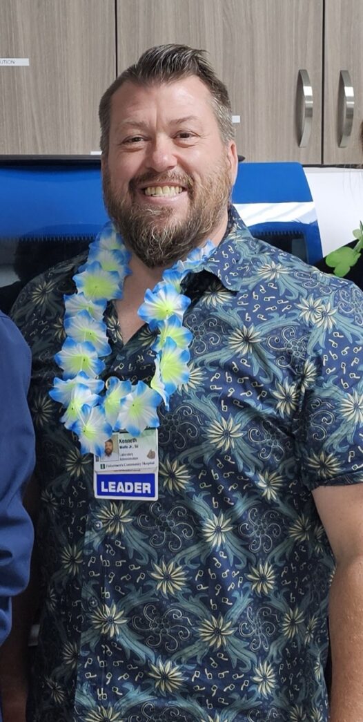 a man in a hawaiian shirt standing next to another man
