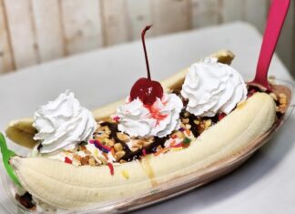 a banana split with whipped cream and a cherry on top